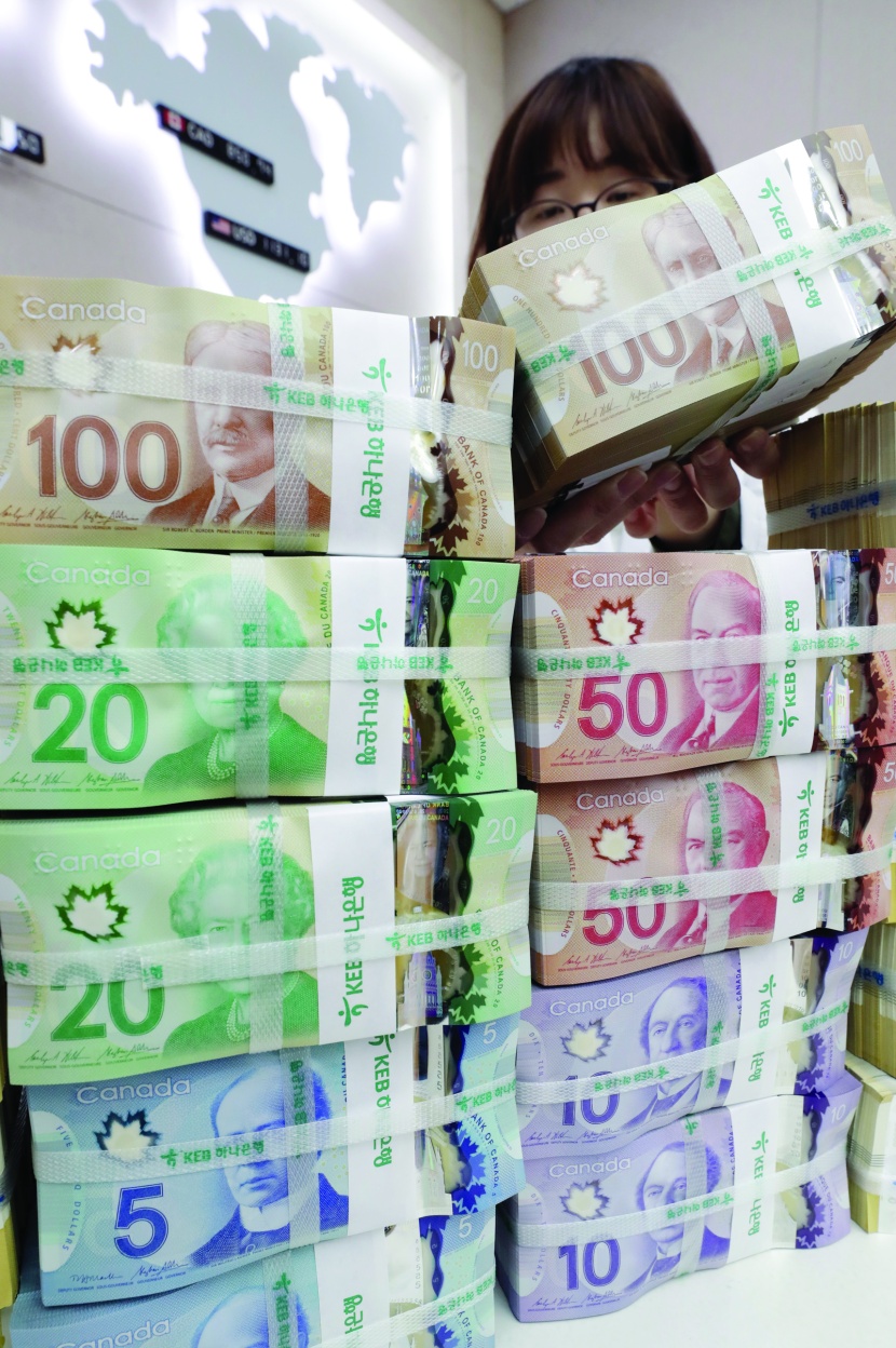 موظفة تصف دولارات كندية داخل بنك تجاري في سيئول