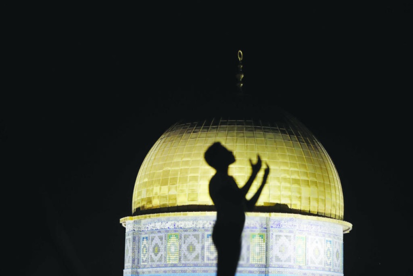 فلسطيني يتضرع إلى الله في ليلة وترية بجانب مسجد قبة الصخرة في القدس المحتلة