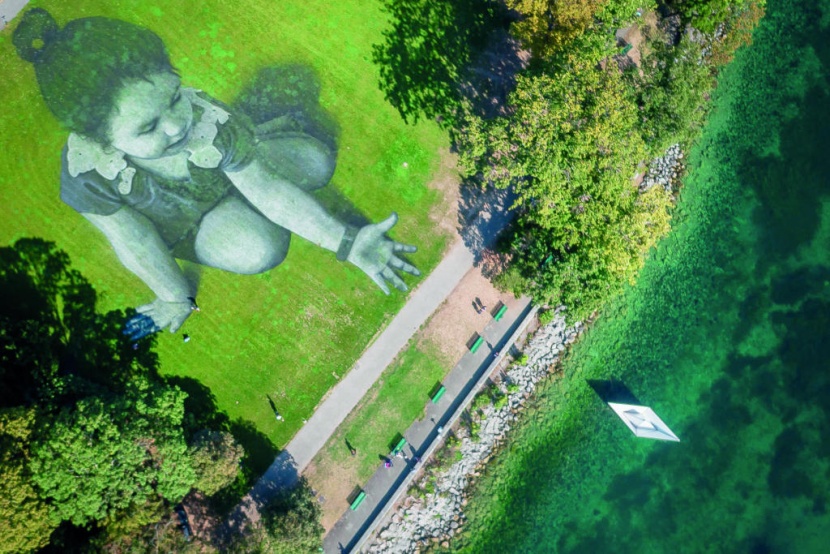 مجسم ضخم لطفلة تمد يدها لزورق أمام بحيرة جنيف