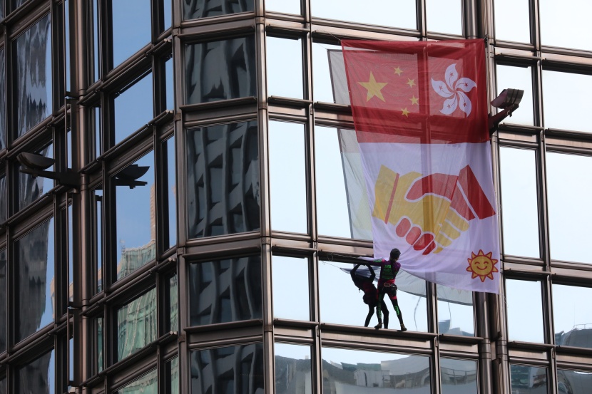 "الرجل العنكبوت" يتسلق برجا في هونج كونج ويرفع راية مصالحة