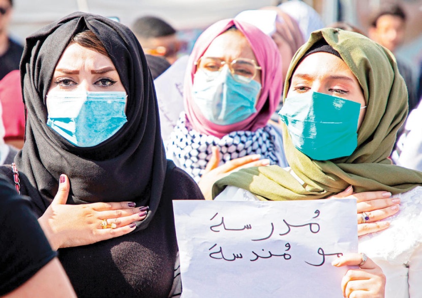 عراقيات يرفعن لافتة كتب عليها «مُدرسة مو مُندسة» خلال مشاركتهن في مظاهرة
مناهضة للحكومة في البصرة