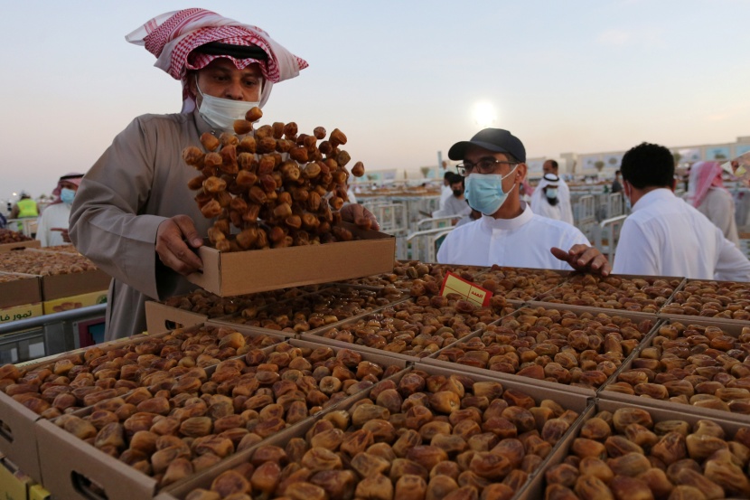 باعة تمور يعرضون منتجات مزارع القصيم في موسم عنيزة للتمور