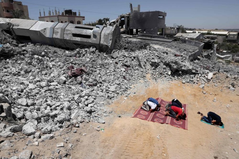 فلسطينيون يؤدون الصلاة بالقرب من أنقاض مسجد شمالي غزة دمره القصف الإسرائيلي
