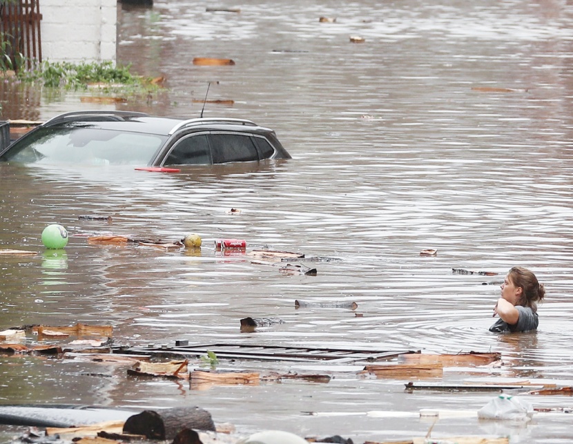 امرأة تحاول عبور شارع غمرته مياه الفيضانات القوية في عدة مقاطعات بلجيكية