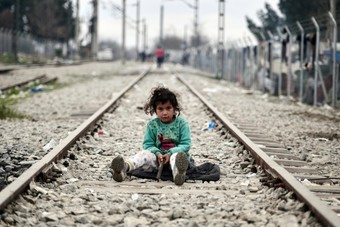 طفلة سورية لاجئة تجلس وسط سكة حديد عند الحدود اليونانية المقدونية.