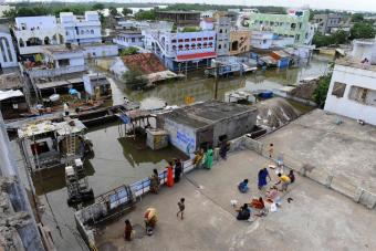 متضررين من الفيضانات في الهند على أسطح منازلهم بعد أن طمرتها المياه في مدينة فيجاياوادا.