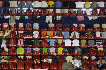 ضحايا الإعصار الذي ضرب الفلبين يضعون ملابسهم على كراسي الصالة الرياضية التي تحولة إلى مركز إجلاء مؤقت في مدينة باسيج لأستقبالهم.